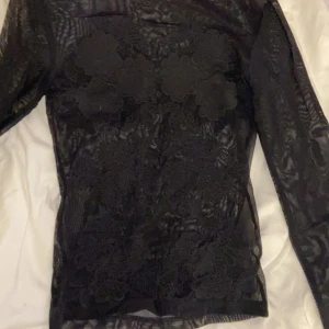 Genomskinlig långärmad tröja med brodering - Säljer min oanvända genomskinliga tröja i strl xs. Väldigt fin och går att använda utan topp under om den sitter rätt men funkar även att ha tröja under, har både broderingar bak och fram