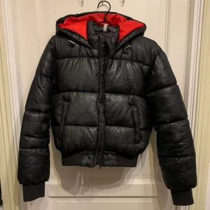 Svart och röd croppad vinterjacka  - Säljer denna coola jackan som ja köpt här på Plick, använt några gånger men är lite för liten. Verkligen så tjock o varm så perfekt till vintern. Finns lite slitningar men märks inte så mycket för materialet är ”glansigt”.