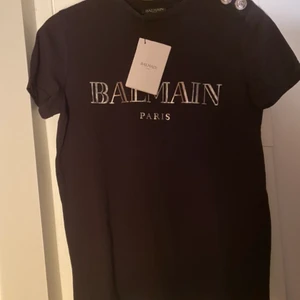 Balmain t-shlirt - Balmain t-shirt i storlek XS köpt på arkivet secondhand på Östermalm i våras. Men då den är något liten till mig så har den inte kommit till användning. Taggsen sitter kvar och jag själv betalade 1100 för den på arkivet. 