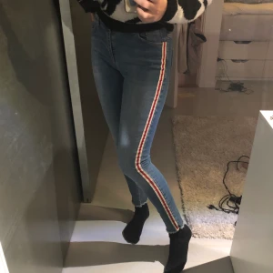 Jeans från Zara - Jag säljer dessa snygga jeans från zara då de tyvärr är för små. De är i storlek 36 men liknar mer en 34. På sidorna är det vit röda ränder och längst ner är tyget räfflat.🦋