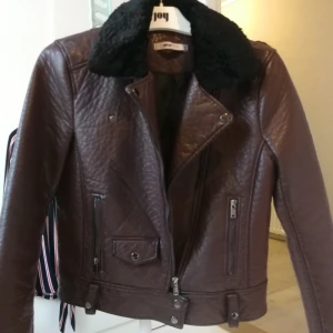 Tjockare vinröd/brun fusk skinn jacka från Gina tricot  - Jätte fin fusk skinnjacka från Gina tricot, köpt på second hand men var nyskick så, använd max 3 gånger. Lite tjockare än vad "vanlig" skinnjacka är så passar bäst för höst. Storlek xs men passar nog även small. 