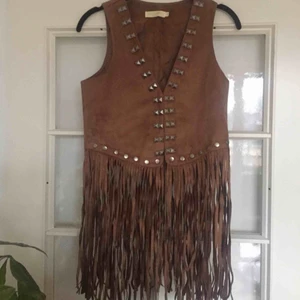  - Jättehärlig mockaväst med fransar och någon slags nitar. Har haft den öppen de få ggr jag använt och då passar den nog XS-M. Stängd sitter den bra på mig som är en klassisk S.