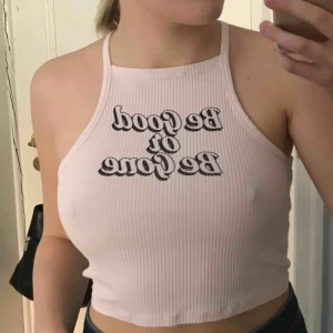  - Ribbat babyrosa halterneck linne med svart text över bröstet. Snygg och enkel topp perfekt till sommaren som har lite old school känsla. Köparen står för frakten :)