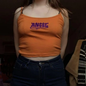  - Säljer orange linne med texten "Angel", knappt använd. 