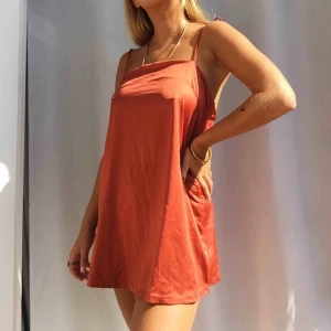  - Superfin rost-röd slip-on klänning. Axelbanden justerar man genom att knyta till den längd man vill ha. Snygg att ha som den är, över en t-shirt eller till ett par snygga kostymbyxor. Ett måste i garderoben