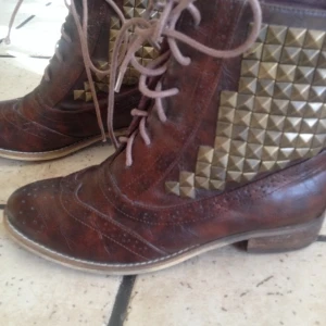 Nästan aldrig använda bruna boots med bronsfärgade nitar från Tiamo. - Nästan aldrig använda bruna boots med bronsfärgade nitar från Tiamo.