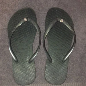 Havaianas mörkgröna Flippflopp st 35-36 - Mörkgröna Flipp flopp från havaianas st 35-36. Eur strl 37/38. Dem är i gott skick och på toppen finns en liten diamant. 