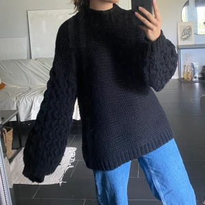 Svart stickad tröja  - Svart stickad tröja i oversize modell, köpt på Boohoo. Armarna är typ kabelstickade. Frakt tillkommer.