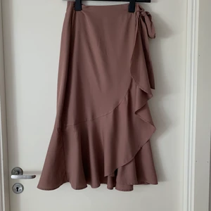 Lila ish kjol från gina tricot - Kjol ifrån Gina tricot i en mörklila färg ish. Använd få gånger, väldigt fint skick. Man knyter banden själv i midjan, därför passar den även en xs. Pris kan diskuteras, buda i kommenterarna eller skriv privat