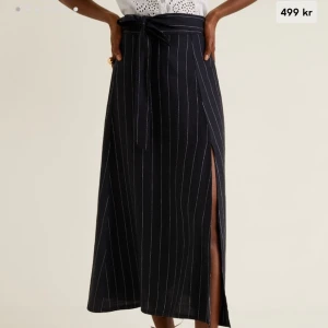 Kjol i 100% linne - Marinblå-vit randig kjol från mango. Har slits på ena sidan och knytning i midjan. Köpt för 500kr och använd en gång