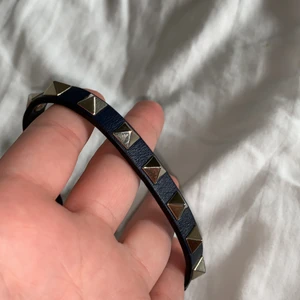 Valentino - Intressekoll på mitt Valentino armband i mörkblått med guldiga nitar. Sparsamt använt. Köpt för 1795kr i VALENTINO affären i köpenhamn. Dustbag och box samt äkthetsbevis medföljer.