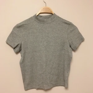  - Ljusgrå T-shirt med polokrage från Monki