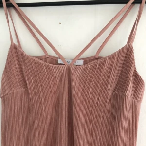  - Skimrig klänning i plisserat material. Långklänning för kortare personer. Är 1.80 och går halvvägs på vaden. Använd en gång, bra skick! + frakt 20kr 