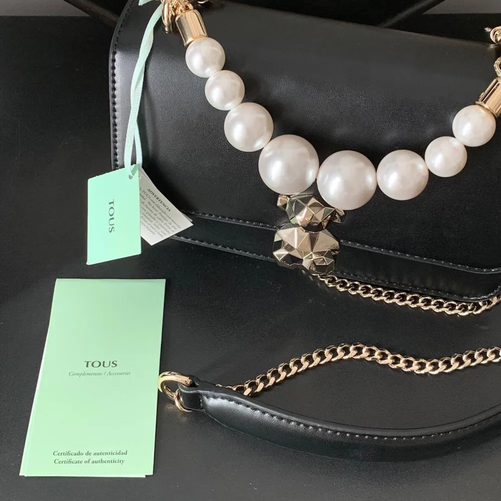 Brand new TOUS bag with tag and authenticity certificate. Never used! In black high quality leather with golden details and pearls strap. Sold out in the online store. . Väskor.