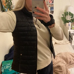 Svart dunväst! - Säljer min älskade svarta väst, den e köpt på mango förra året (för 350 kr). Den är jättesnygg att ha över en hoddie eller liknande! Jag skulle även säga att den är bra på att hålla värmen kunde ha den förra vintern utan att frysa!💖