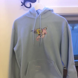 Hoodie med spongebob broderi - Jättefin blå färg med ett gulligt broderi. Tyvärr missfärgning på fickan därav det billiga priset. Någon kreativ kanske kan fixa de annars syns det inte om man stoppar ner tröjan i byxorna.