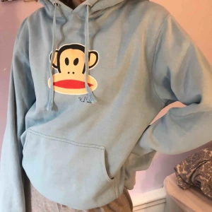  - Ljusblå hoodie med apa på.