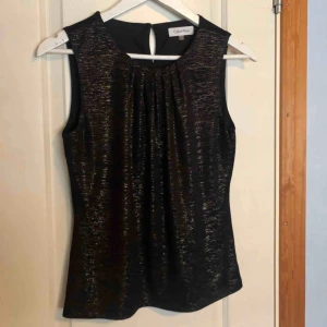  - Glittrig topp från Calvin Klein som passar perfekt till festliga tillfällen! Super fint material och använd cirka 3 gånger så i perfekt skick. ❣️ Köpt i New York. 