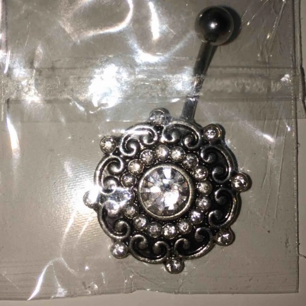 Oanvänd navelpiercing. Säljes pga det inte riktigt är min stil. Jättefin annars!  Material: 316L - Kirurgiskt Stål + STRASS . Accessoarer.