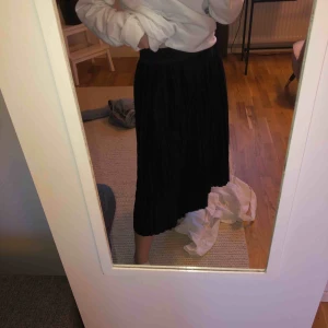  - Lång plisserad, svart kjol med glitterkant upptill från Monki, i storlek M men passar S, fint skick. Köparen står för frakten.