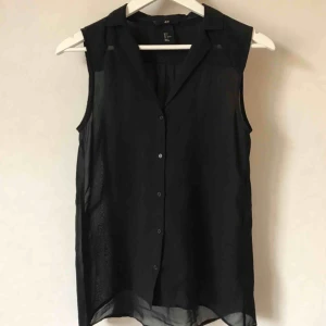  - Skir svart ärmlös blus med veckad rygg. Genomsläppligt mjukt sidenliknande tyg.  Kan mötas i Stockholm eller skicka mot fraktkostnad! ✨🌸✨