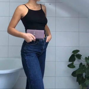  - En lila plånbok med en broderad fjäril på. Har mycket plats inuti för både kontanter, kort och ett ID-fodral! 