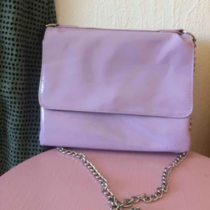  - Lila väska med fyra fack, två med dragkedja. Kedjeband. Rymmer hyfsat mycket! Fraktkostnad tillkommer, kan också mötas upp i Malmö.