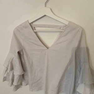  - Vit blus med volangärmar 