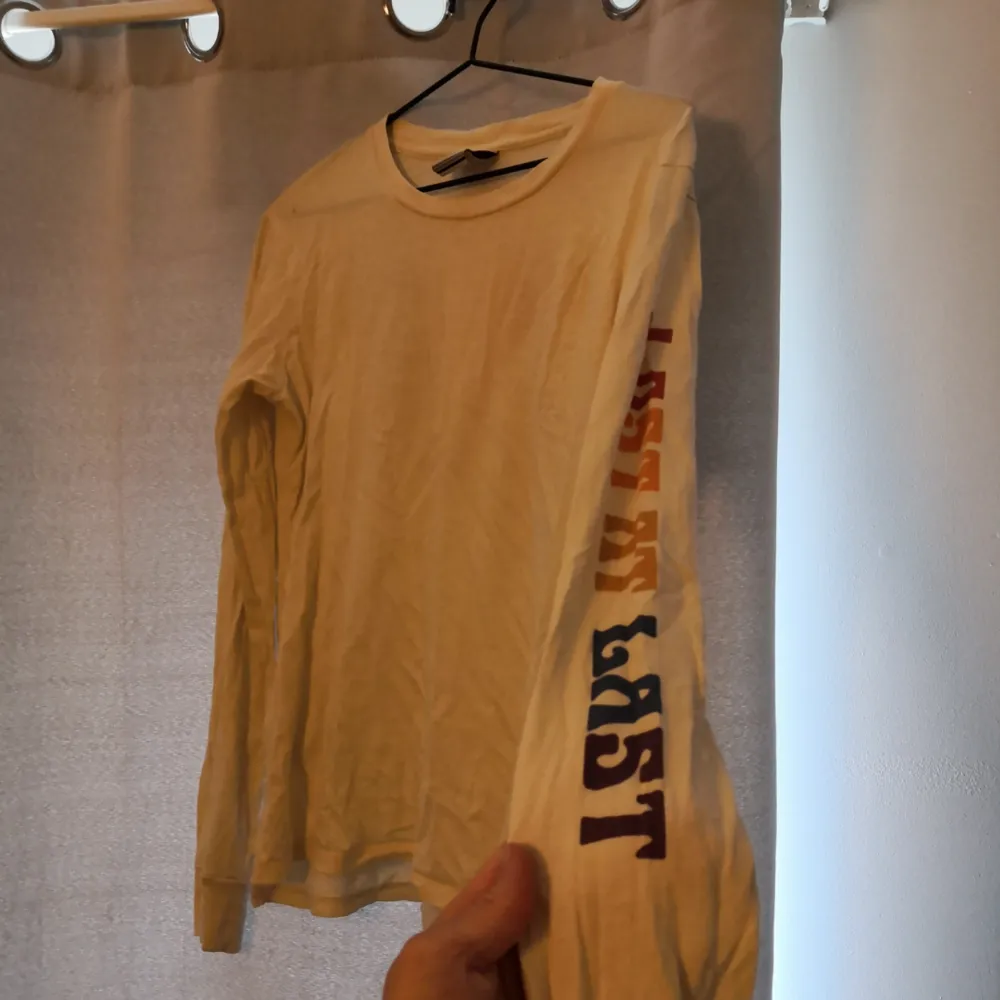 Härlig långärmad beige t-shirt från Burton med tryck på rygg samt vänster arm 