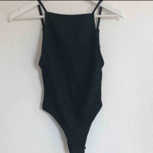 Glittrig string body - Superfin svart glittrig body med djup rygg. Superfin och knappt använd, strl XS från Gina Tricot. Eventuell frakt tillkommer 💗⚡️