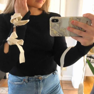  - Säljer denna super gulliga svarta långärmade tröjan från Zara som har två stycken rosetter på vardera ärmar. Storlek S!! 