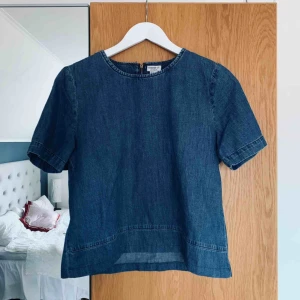  - T-shirt i jeansmaterial. Var från början en klänning men har sytt om den till en topp. Tröjan är lite kortare och bredare i modellen. Storlek M men passar bättre på XS/S