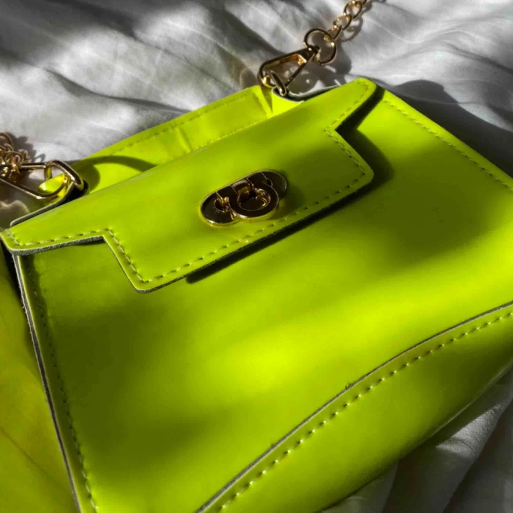 Liten väska i neon gul/grön med guld kedja! Köpt för ett tag sedan men är ej använd. Skriv till mig om du är sugen! . Väskor.