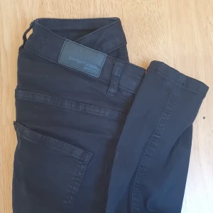 Jeans - Svarta jeans från Gina Tricot med egengjorda slitningar. Skinny jeans i modellen Molly med hög midja. Använd max 5 ggr