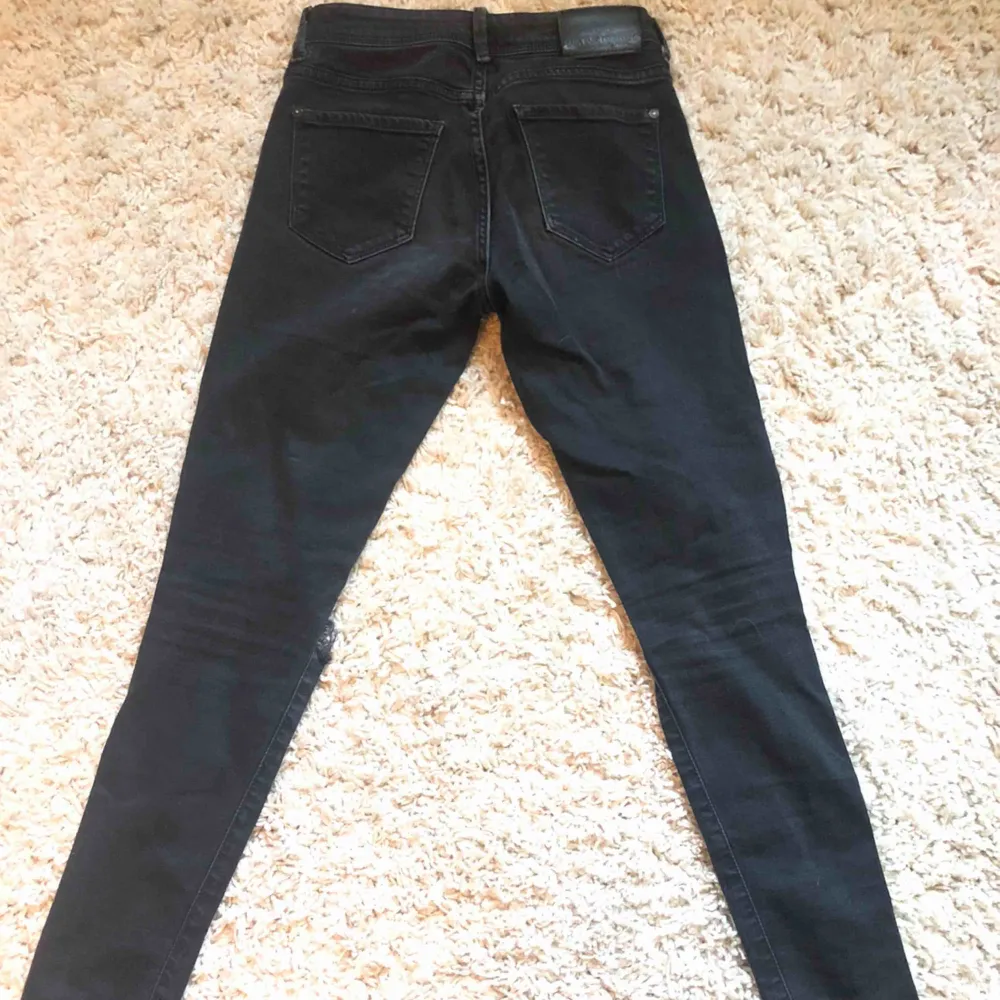 Svarta jeans med egen klippta hål vid knäna. . Jeans & Byxor.