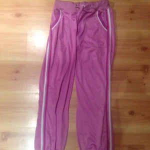  - Rosa träningsbyxor i använt skick! Står L i lappen men uppskattar till M. Lätt högmidjade. 