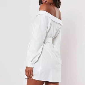 Skjortklänning - Vit skjortklänning med off shoulder och skärp. Endast använd en kväll så den är i princip som ny! Storlek 40 men liten i storleken så skulle säga att den skulle passa 36/38 också!!