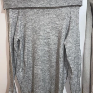 Off shoulder stickad tröja - En grå stickad off shoulder tröja. Oanvänd. Nypris 399.