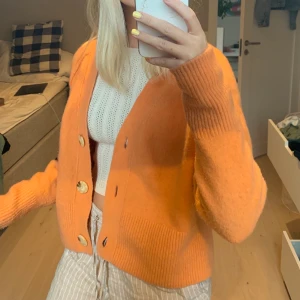 stickad kofta - stickad kofta i ullblandning i en jättehärlig aprikos/orange färg. jättebra kvalitet, storlek xs men passar s också. koftan är mer aprikos i verkligheten än vad den ser ut på bild 💕😊 köpare står för frakt