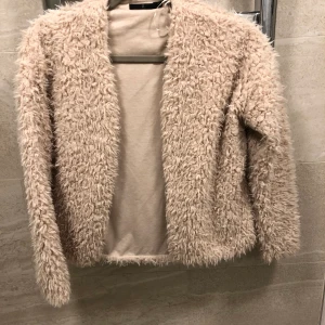 Mysig teddykofta - Beige kofta i teddymaterial, sparsamt använd så skicket är väldigt bra. Storlek 34/XS