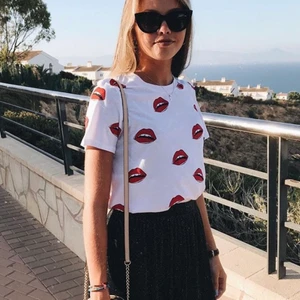 T-Shirt - Säljer en vit t-shirt med röda munnar på. Storlek M men skulle säga att den är mer som en S. Frakt tillkommer!!