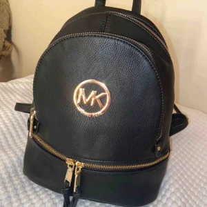  - AAA-kopia Michael Kors ryggsäck. En liten gullig super snygg och classy ryggsäck. Svart imitationsläder med guld detaljer. Säljes pågrund av att den inte kommer till användning. Nästan aldrig använd, som nyskick 🥰
