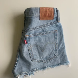 Levis shorts  - Ljus blå Levis shorts med lite slitningar. Storlek 25 modell 501. Använda ett fåtal gånger och ser ut som nya och sitter jätte fint på. Säljer pågrund av att de är för små för mig. (OBS! Frakt tillkommer i priset)