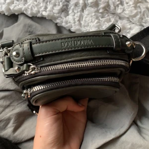 Väska  - Supersnygg grön väska från dondonna använd 3 gånger pga att jag har för många väskors den kommer aldrig till användning! Lagom storlek perfekt om man vill ha en liten detalj! Mörk grön färg som ses som svart för många:) Köparen står för frakt! Budgivning👇