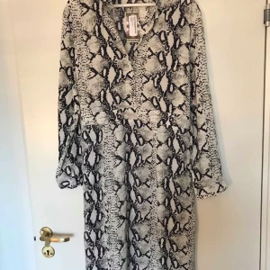 Skjortklänning  - Helt ny skjortklänning med fint djurmönster.  En vid modell, passar bra som den är eller med ett bälte.🌸 köparen står för frakt. 