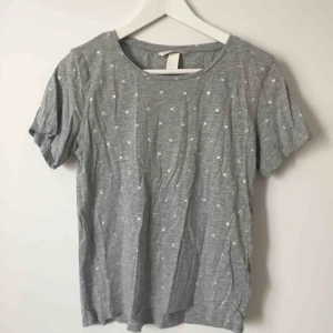  - T-shirt från H&M i grått med små silvriga palmer. Knappt använd.