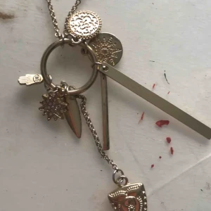  - Guldigt halsband me massa olika berlocker 