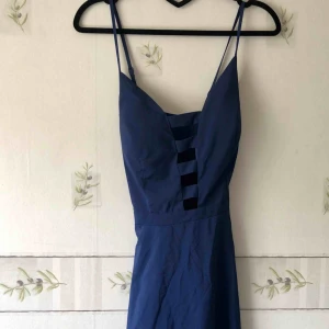  - Fin djupblå klänning som aldrig är använd. Jag är 162 och på mig så slutar den straxt under knäna. Vadderade ”kupor”.