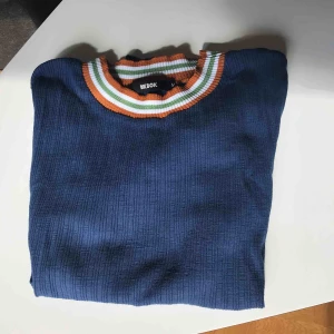  - Ribbad topp i mörkblå färg. Fina detaljer på ärmar och krage. Fräsch och använd ett fåtal gånger. 