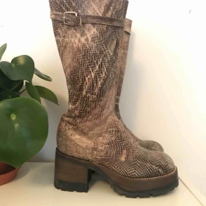 - Helt oanvända ormskinsboots med platåååå från Buffalo, från slutet av 90-talet! Dragkedja på sidan och avtagbart spänne längst upp på skaftet! Liten 40 så skulle passa en 39!